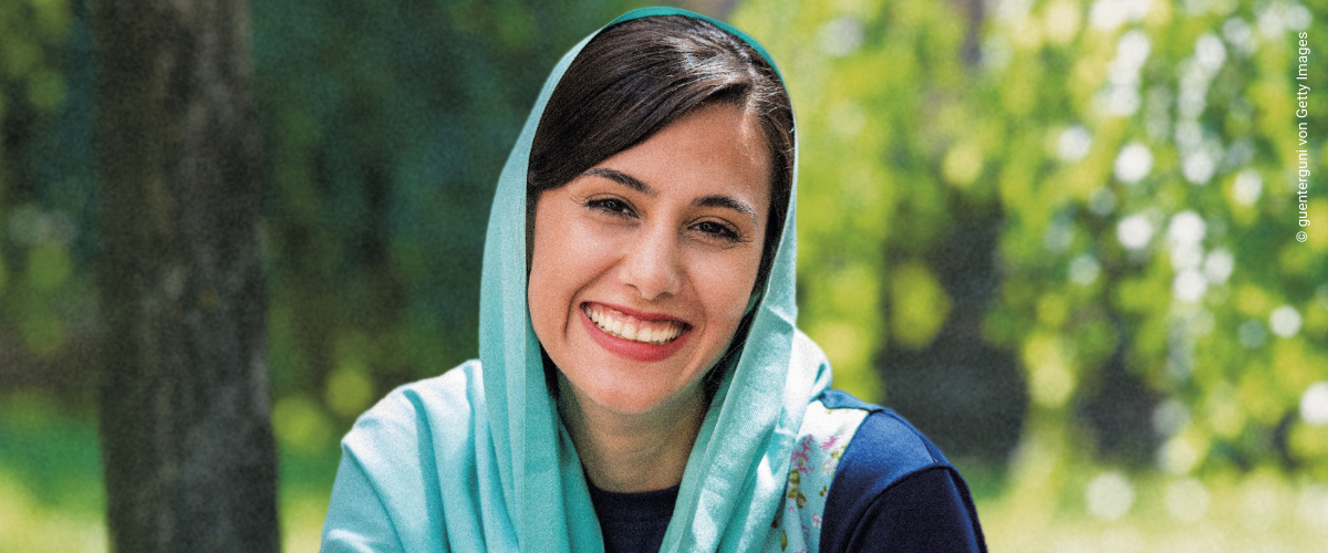 Lächelnde Frau mit Kopftuch im Park